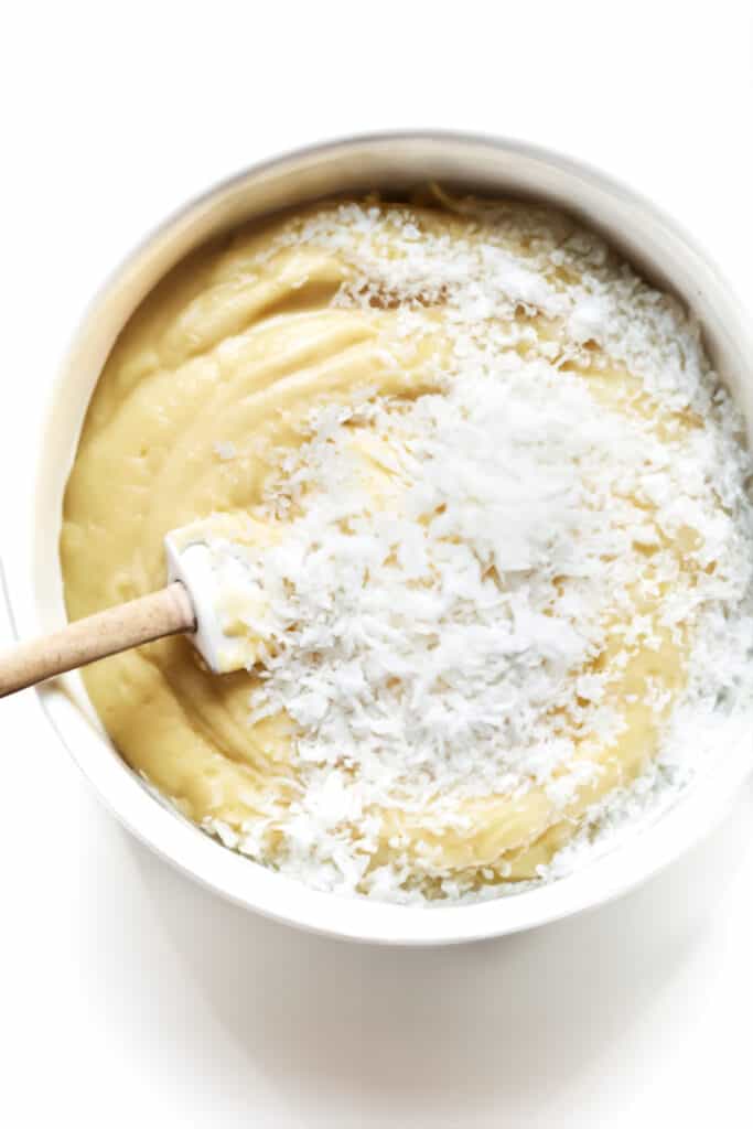 the coconut added to the custard in a bowl