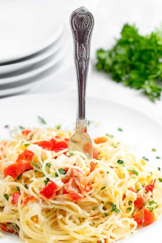 a fork twirling the crab pasta on a white plate