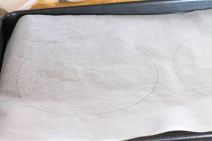 Two circles drawn on baking paper on a baking sheet