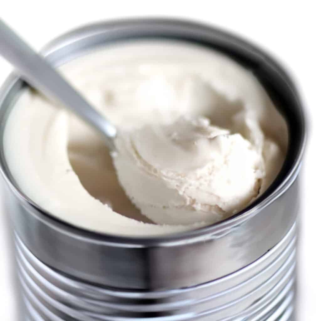 a close up image of a can of coconut cream with a spoonful in the can