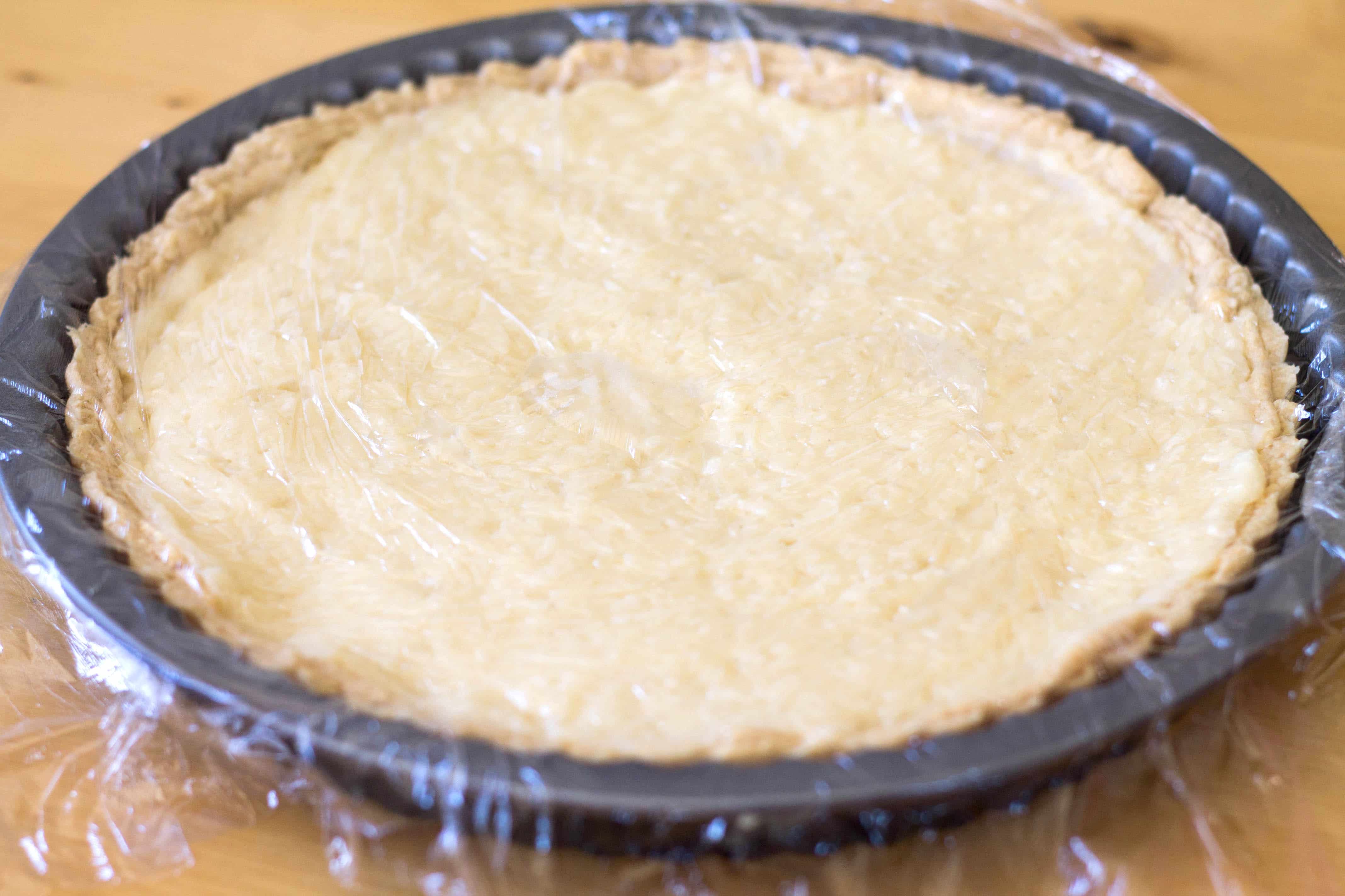 Coconut Cream Pie covered with plastic wrap