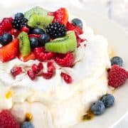 Pavlova with strawberries, blueberries, raspberries, blueberries, kiwi, and passionfruit