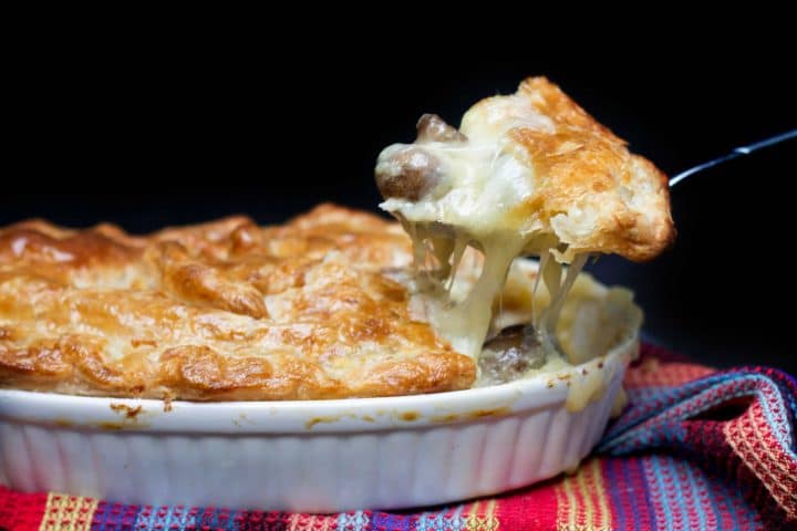Cheesy Chicken & Mushroom Pie with a spoon scooping out a serving
