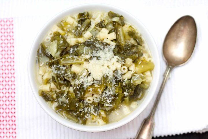 Escarole & Pasta Soup in a bowl with a spoon beside it