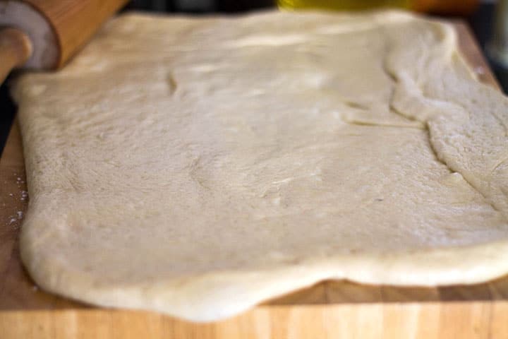 The rolled out dough on a floured cutting board