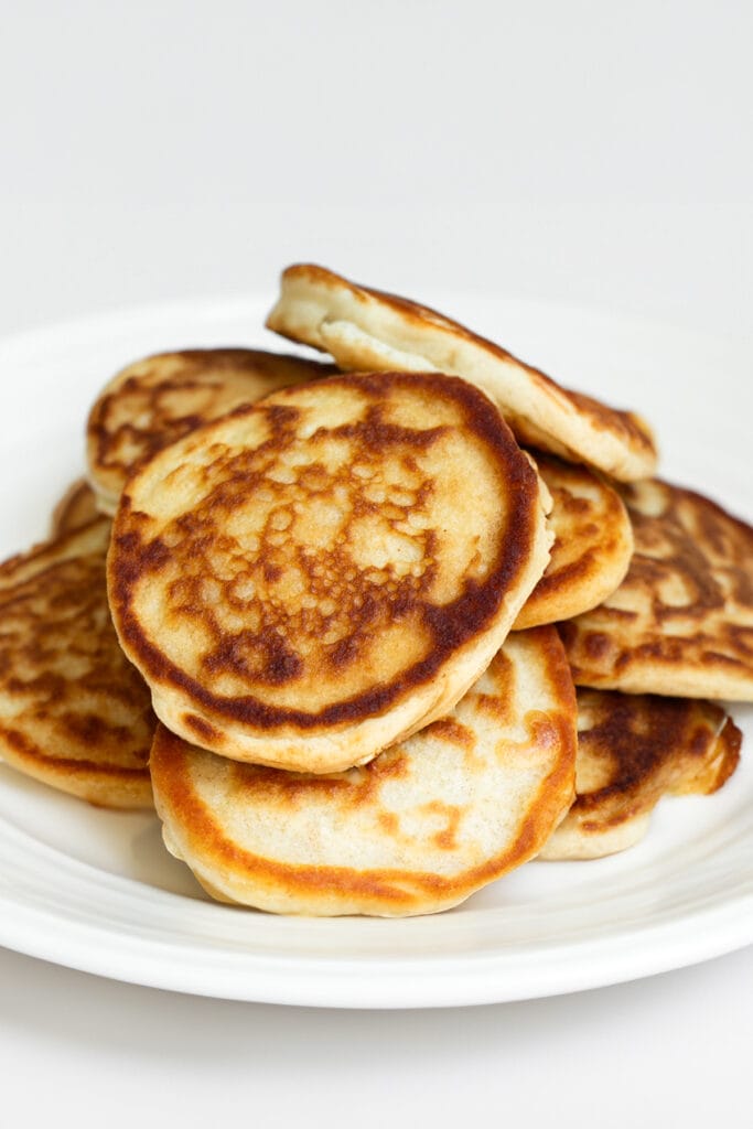 a plate of freshly cooked Scotch pancakes piled onto each other.