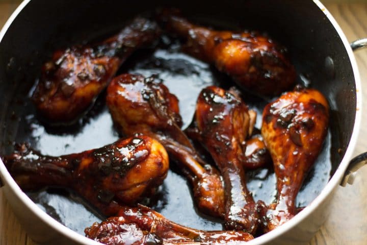 The cooked Chinese chicken in the pan with shiny brown sauce.