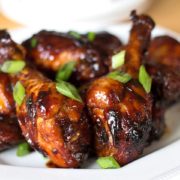 A plate of sticky Chinese chicken with chopped green onions