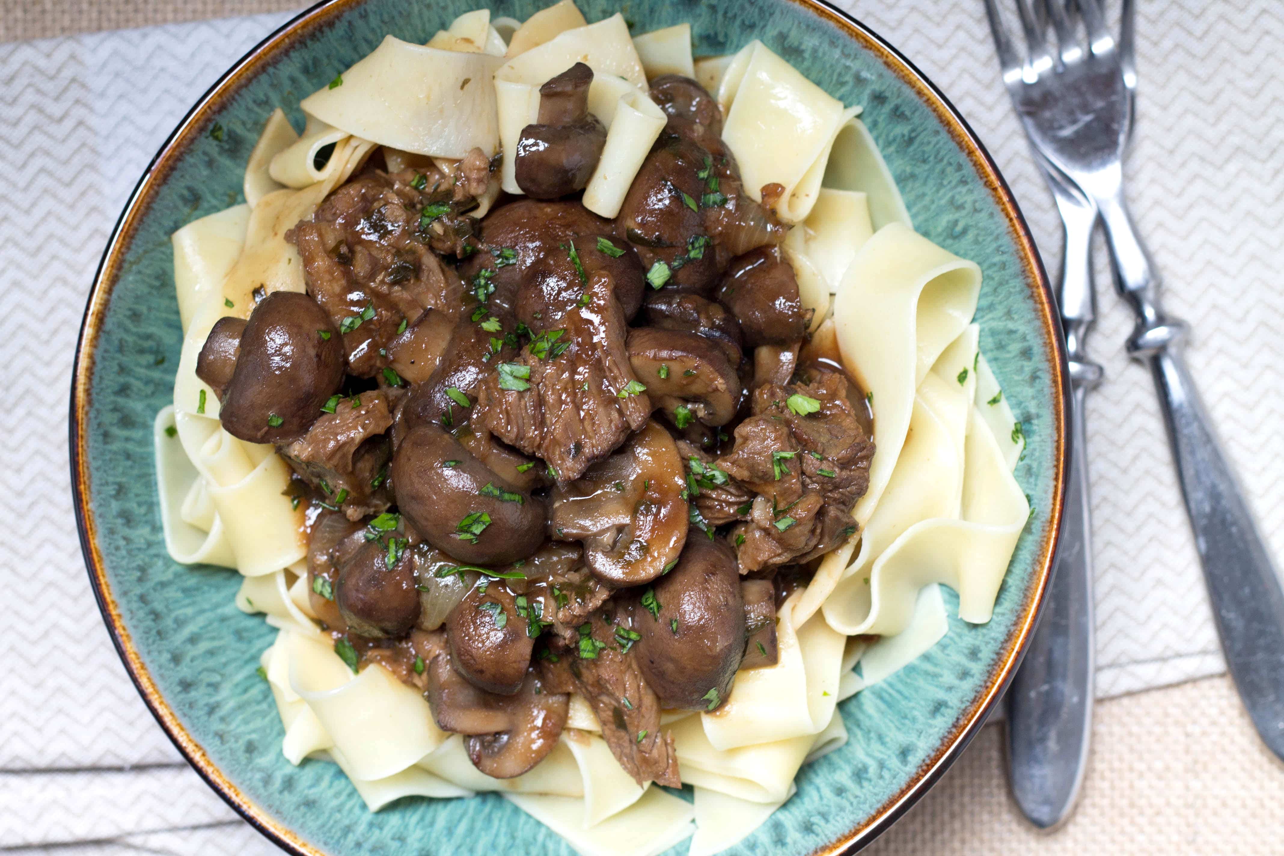 Slow Cooker Beef & Ale with Mushrooms in a dish with pasta