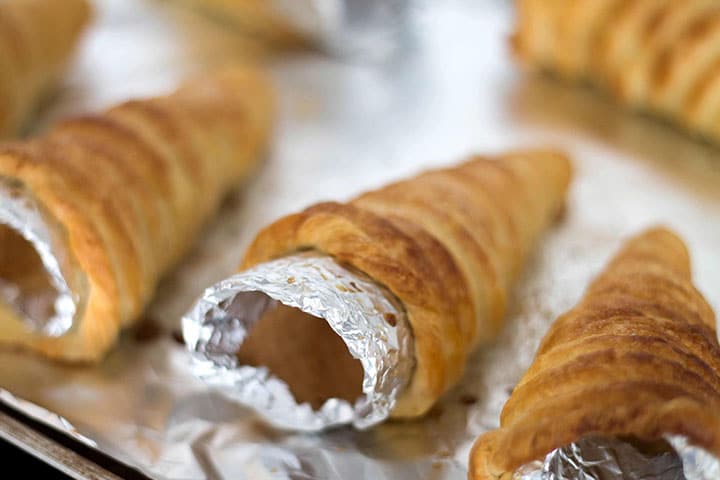 A close up of the baked cream horn still on the cone.