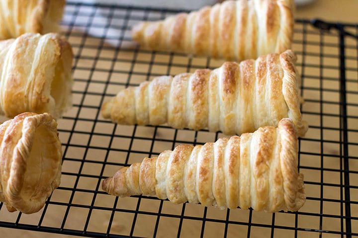 The golden brown, baked horns cooling on a cooking rack