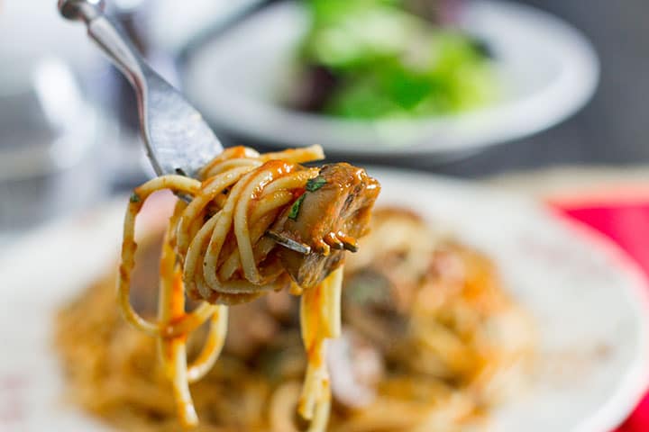A fork with the Spaghetti With Mushroom Tomato Sauce twirlled around it and ready to eat