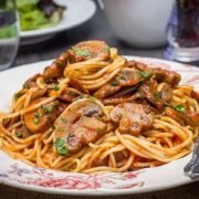 A dish piled high with Spaghetti With Mushroom Tomato Sauce