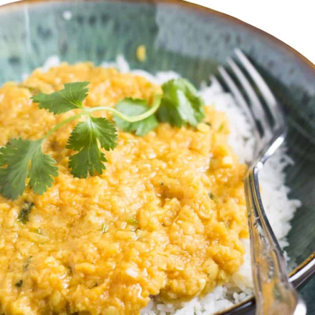 bright Tarka Dal on top of white rice in a bowl