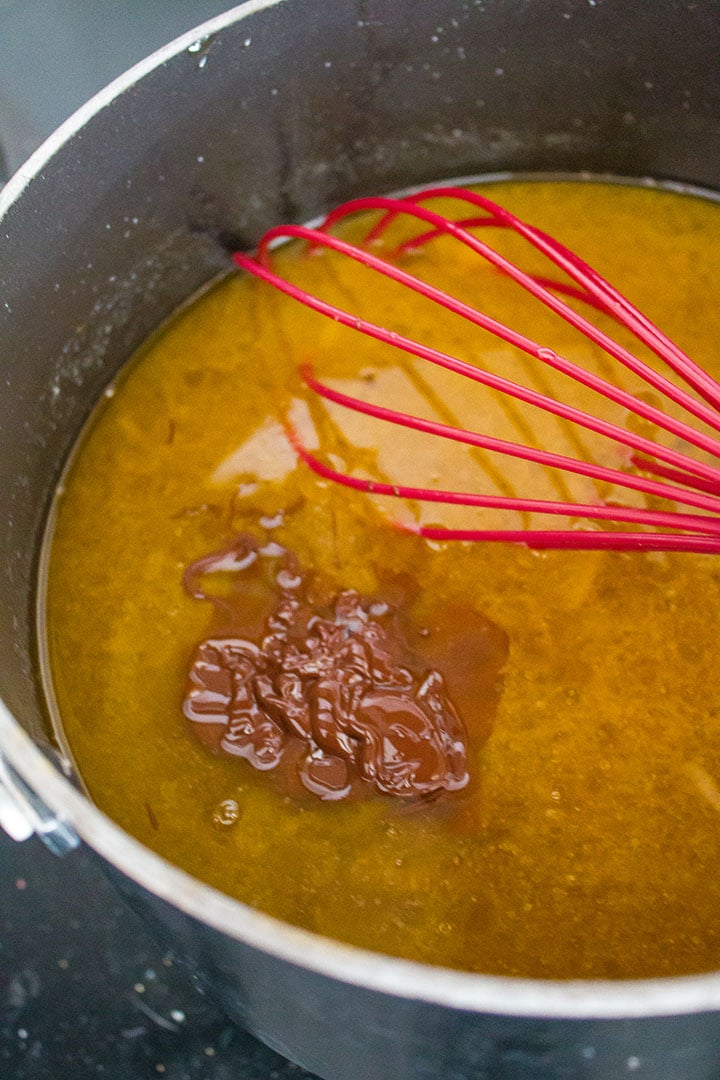 Melted chocolate being added to the butter mixture