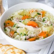 A bowl of Chinese noodle soup with crackers