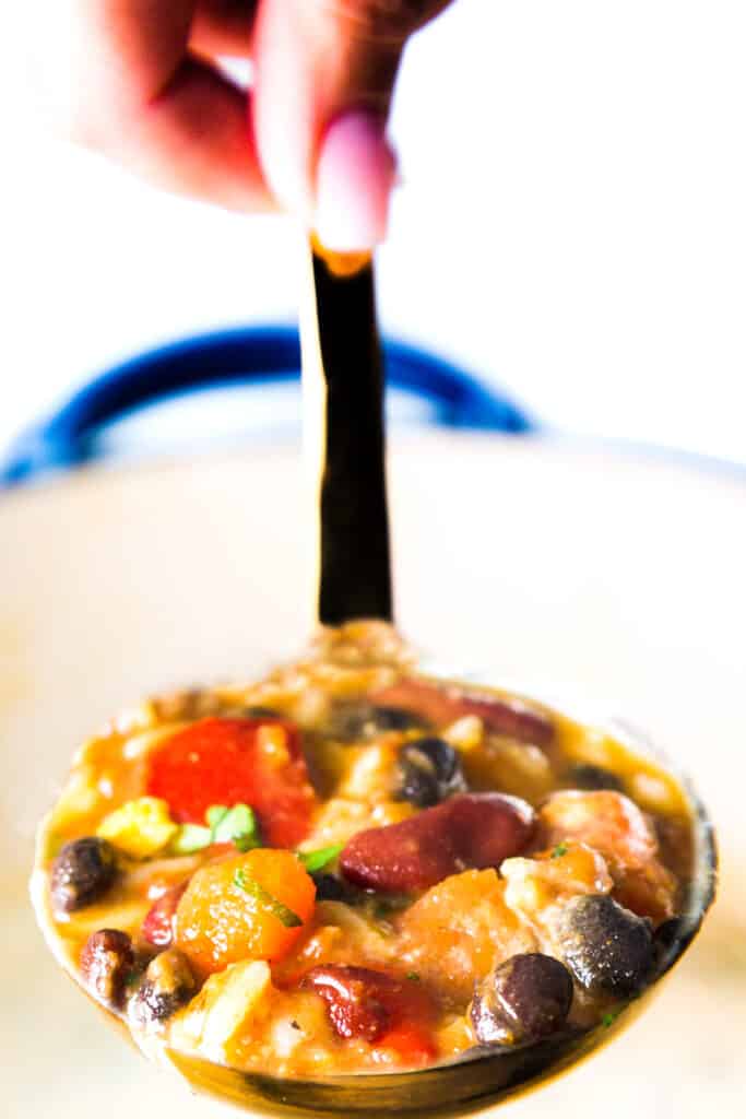 a ladle full of mexican soup with beans and rice