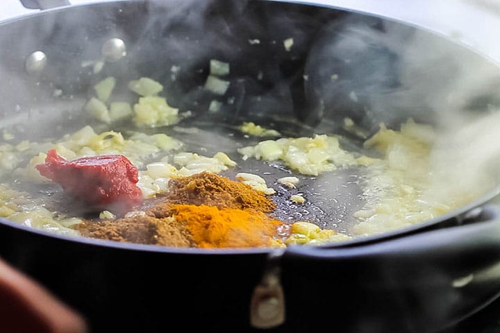 cumin, turmeric, and garam masala, and tomato paste added to the pan with the onion garlic and ginger