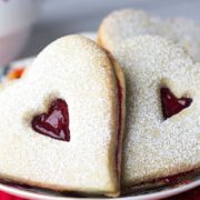 A close up of a plate of heart shaped raspberry butter cookies