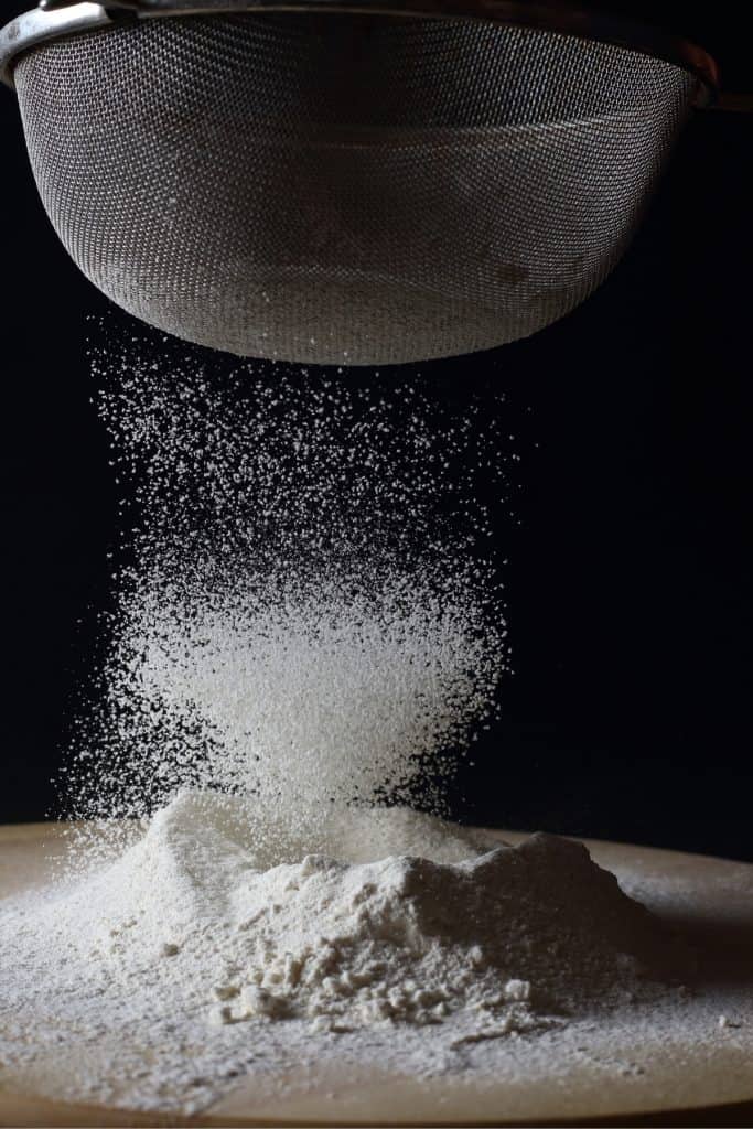flour being sifted through a sifter