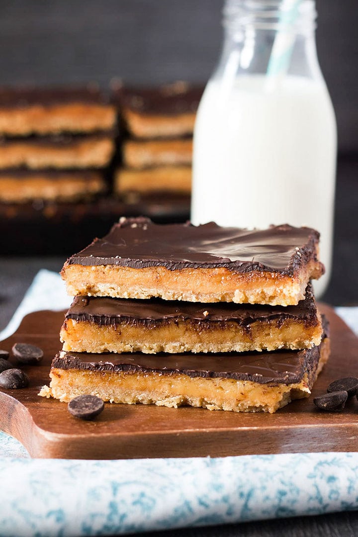 three Toffee bars stacked on top of each other with a little bottle of milk in the background