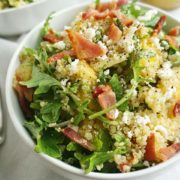 A bowl of bacon quinoa salad with lemon dijon dressing shot from above