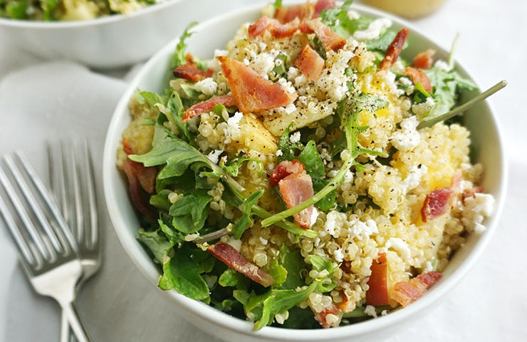 A bowl of bacon quinoa salad with lemon dijon dressing shot from above