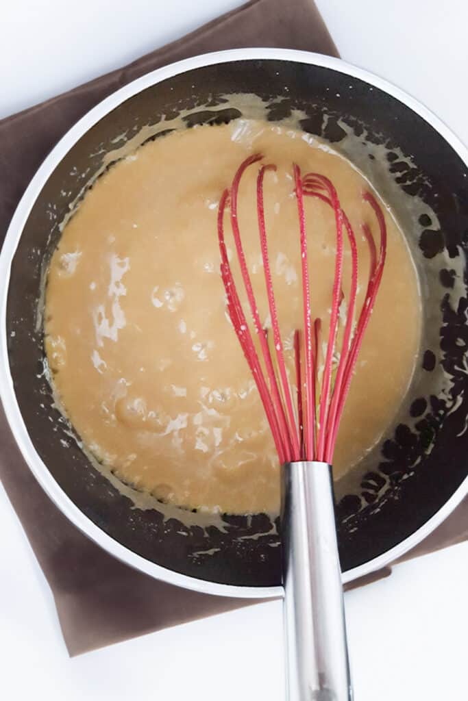 the condensed milk mixed into the caramel mixture in the pot.