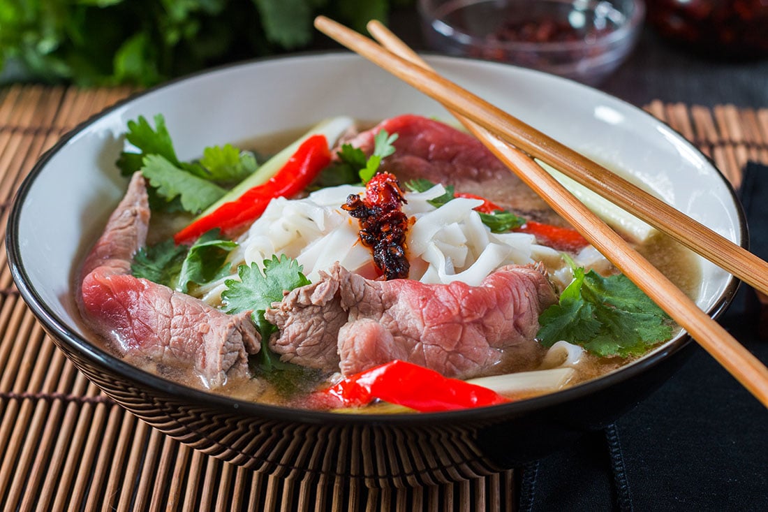 Tuan's Vietnamese Beef Noodle Pho in a black bowl with chop sticks