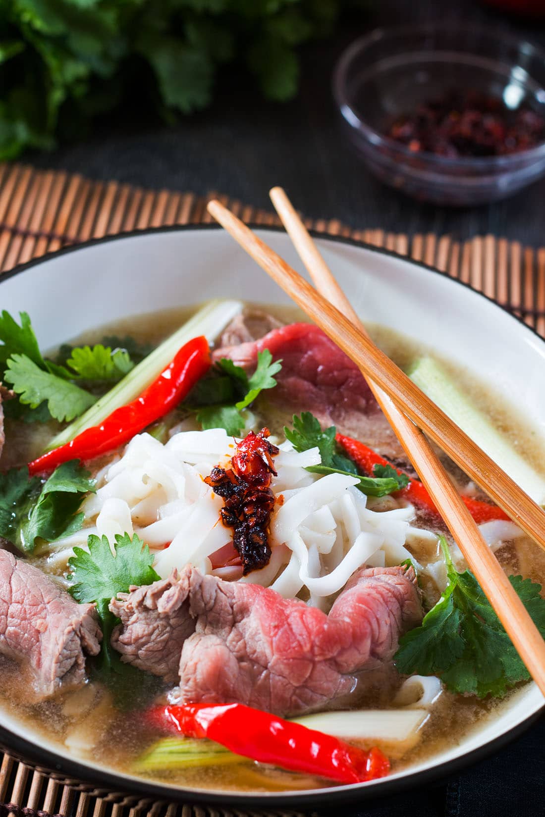 Tuan's Vietnamese Beef Noodle Pho in a bowl with chop sticks and garnish