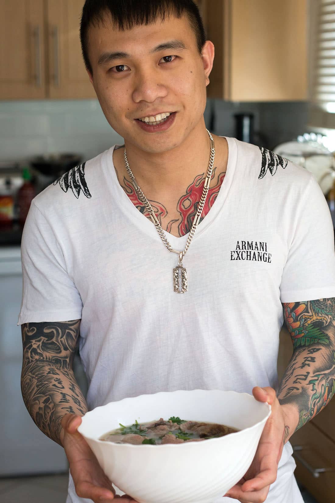 Tuan holding a bowl of his Vietnamese Beef Noodle Pho