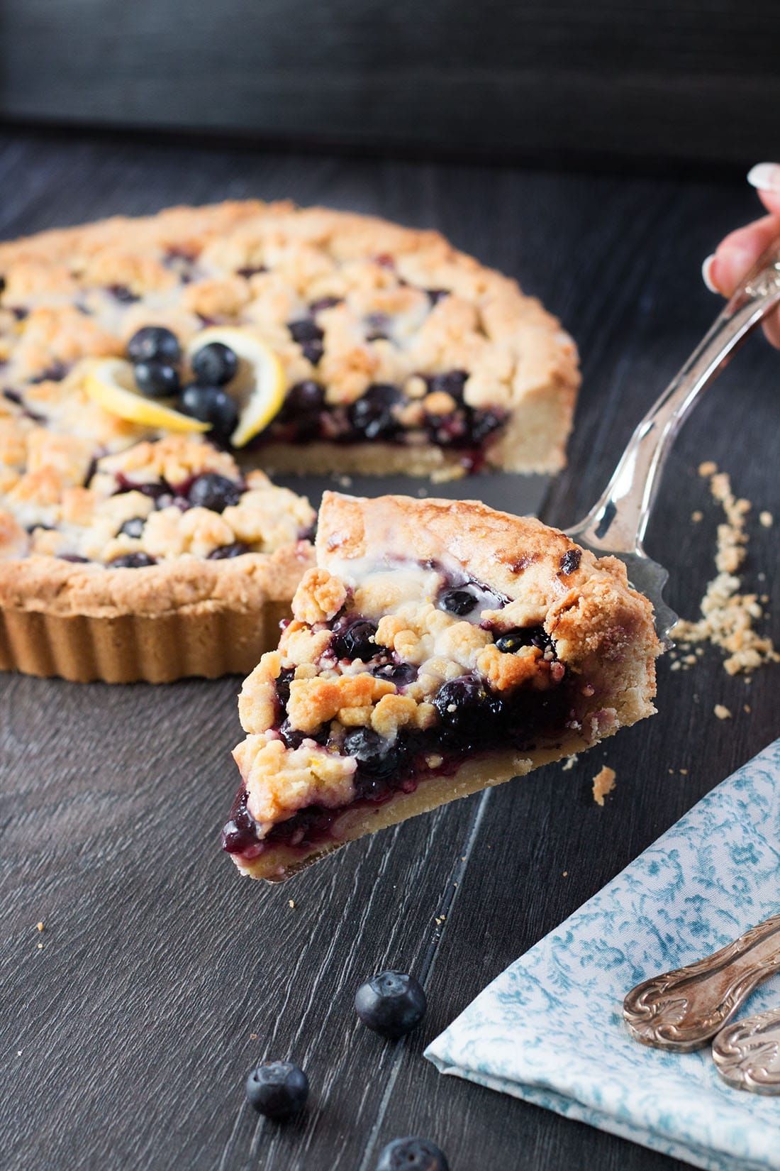 Blueberry Pie just got a sweet and lemony makeover with this recipe for Blueberry Lemon Shortbread Tart. This tart has a buttery, lemon infused, melt in your mouth shortbread base with a luscious, sweet blueberry filling. To top it off, a crumble of the lemon shortbread. It's a summer dessert you won't soon forget.