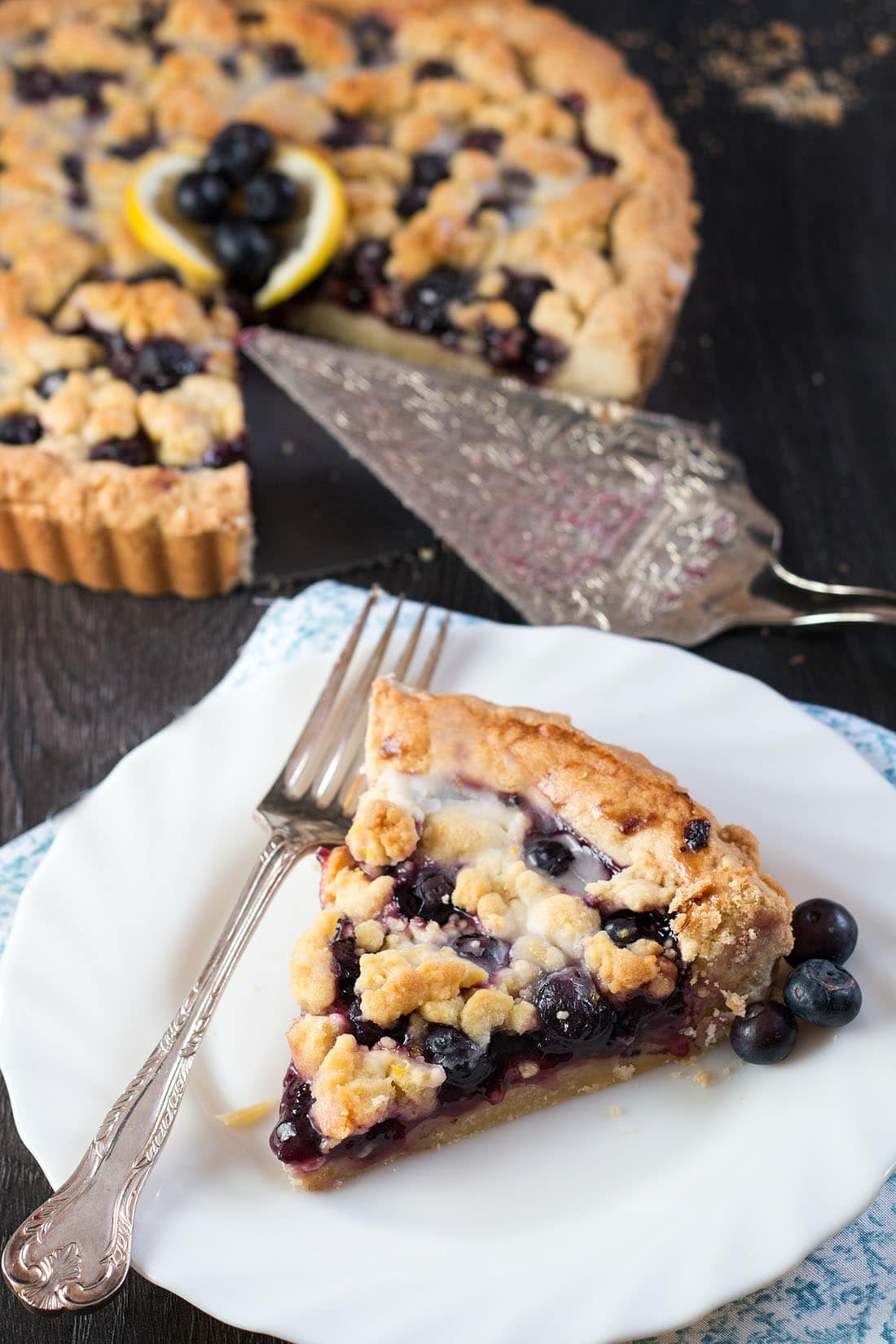 Blueberry Pie just got a sweet and lemony makeover with this recipe for Blueberry Lemon Shortbread Tart. This tart has a buttery, lemon infused, melt in your mouth shortbread base with a luscious, sweet blueberry filling. To top it off, a crumble of the lemon shortbread. It's a summer dessert you won't soon forget.