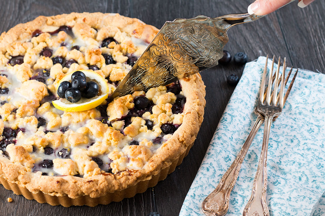 Blueberry Pie just got a sweet and lemony makeover with this recipe for Blueberry Lemon Shortbread Tart. This tart has a buttery, lemon infused, melt in your mouth shortbread base with a luscious, sweet blueberry filling. To top it off, a crumble of the lemon shortbread. It's a summer dessert you won't soon forget.