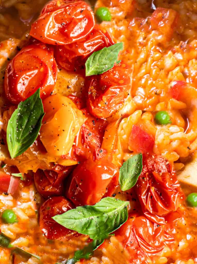 A close up of tomato risotto with roasted tomatoes on top