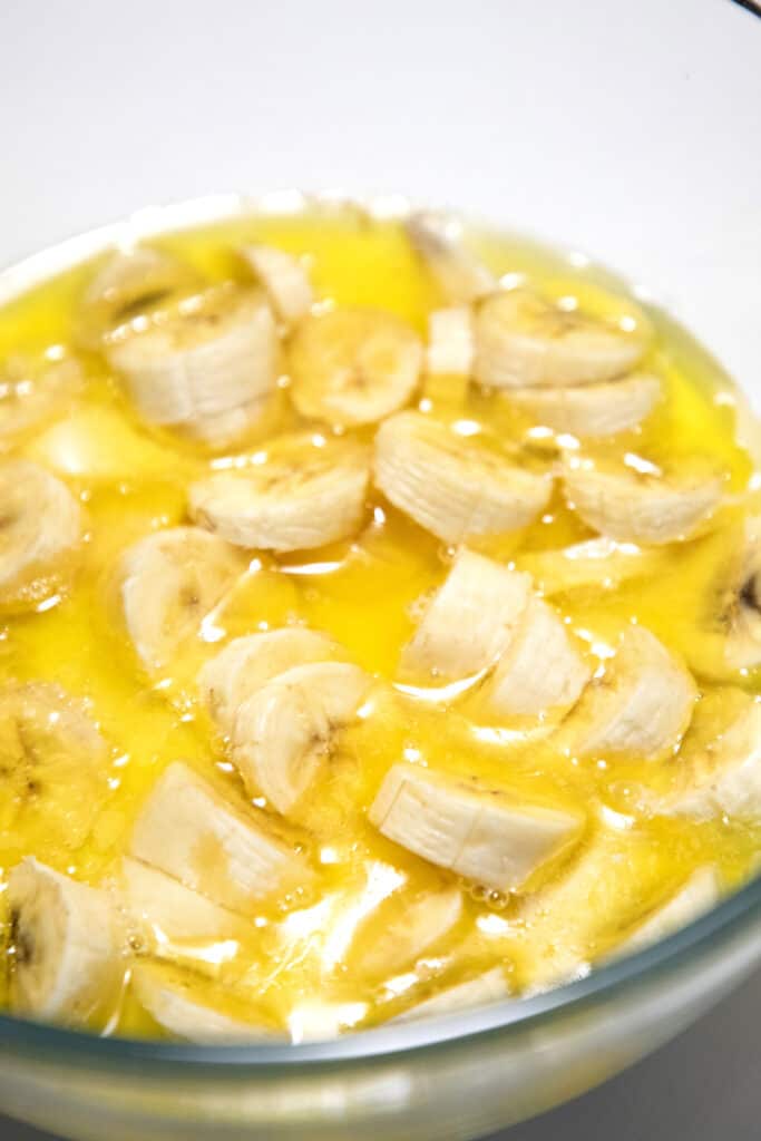 sliced bananas in melted butter