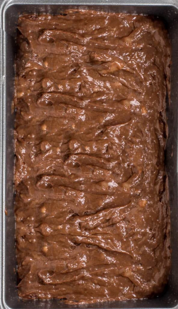 cake batter in a loaf tin with chocolate chips on top