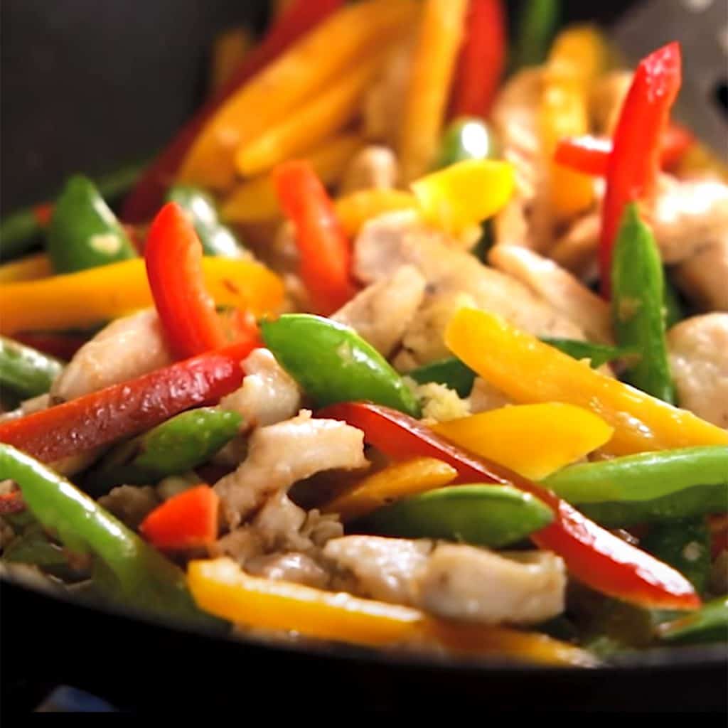 peppers and onions cooking in a pan