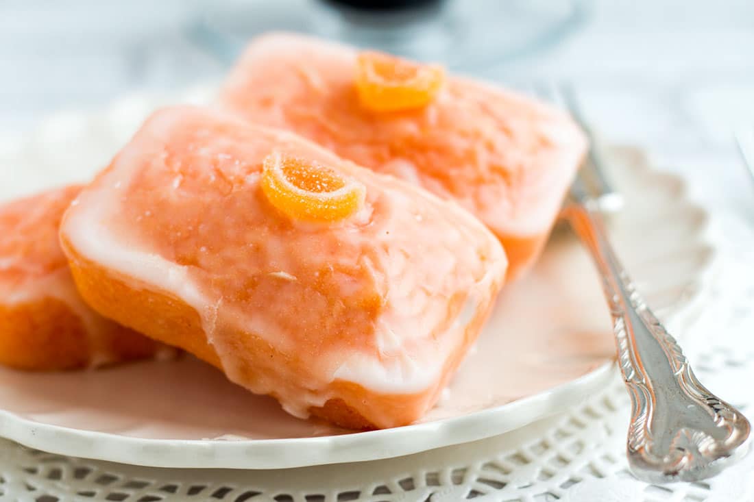 Three Orange Glazed Cakes on a plate with a fork