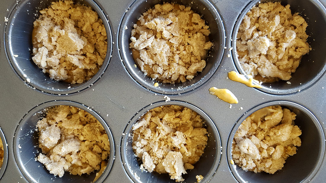 The cake batter in the pan with the crumb added
