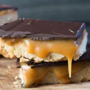 two pieces of billionaires shortbread on top of each other with caramel dripping down