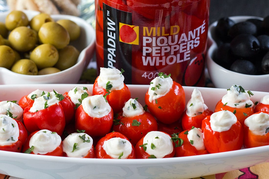 A platter with the stuffed peppers and a jar of peppers in the background.