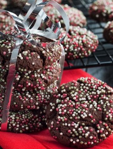a stack of festive Chocolate Christmas Crinkle Cookies tied together with a ribbon