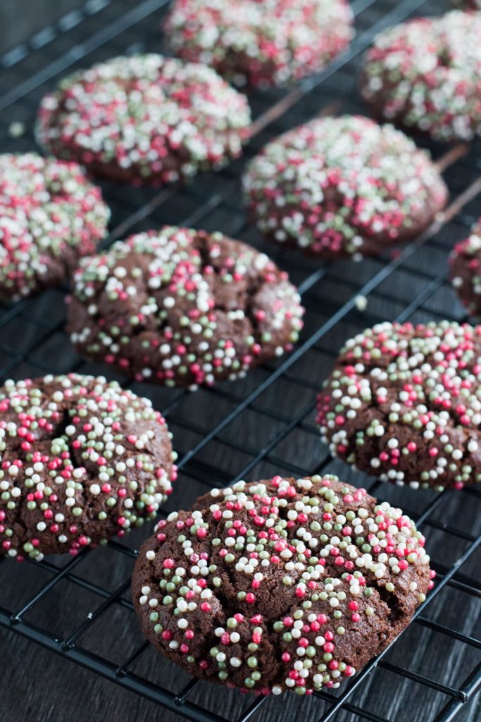 Baked Chocolate Christmas Cookies covered in sprinkles on a cooling rack