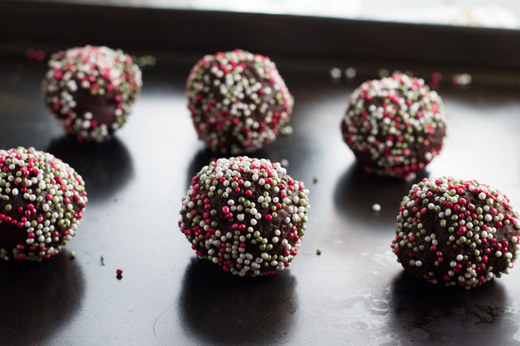 Chocolate Christmas Cookie dough rolled into balls and covered in sprinkles