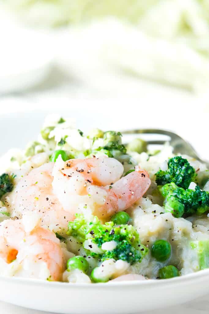 a plate if Easy Lemon Shrimp Risotto with broccoli and peas