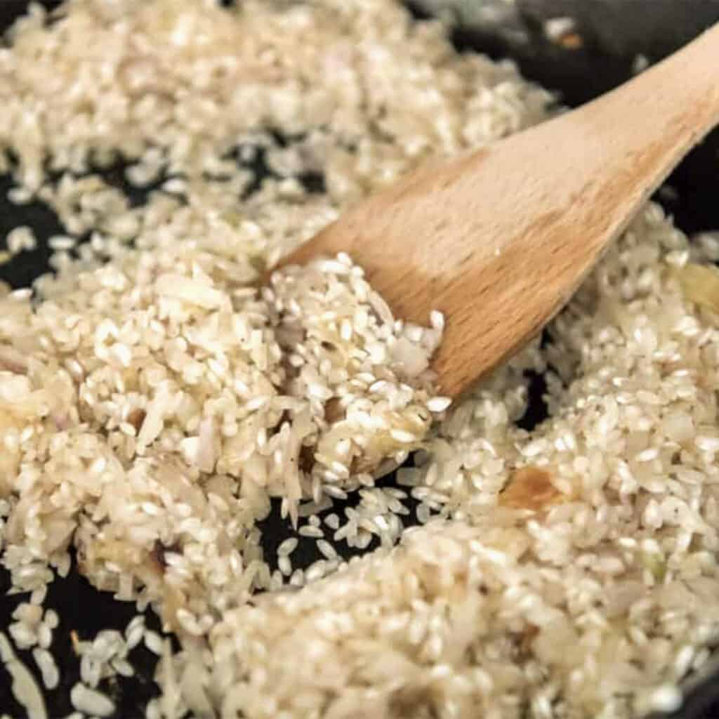 rice garlic and shallots cooking in a pan