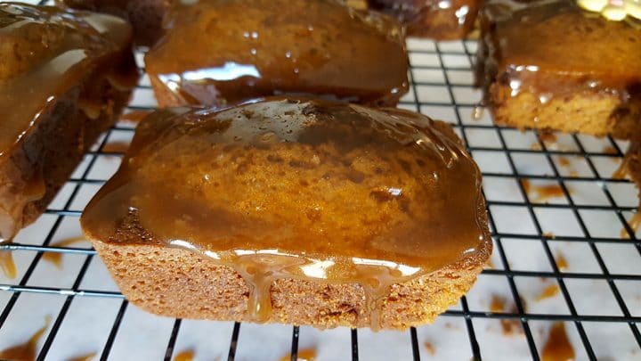 Ginger Cakes just dipped in the sticky toffee glaze on a cooling rack