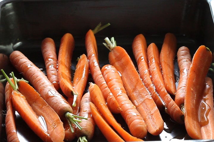 The butter mixture poured onto the carrots in the pan