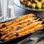 Buttery Balsamic Garlic Roasted Carrots on a serving dish sprinkled with parsley